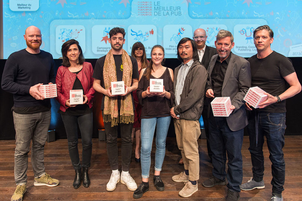 Les vainqueurs de l'édition 2018 du Meilleur de la Pub avec les cofondateurs du prix en deuxième plan : Victoria Marchand et Thierry Weber